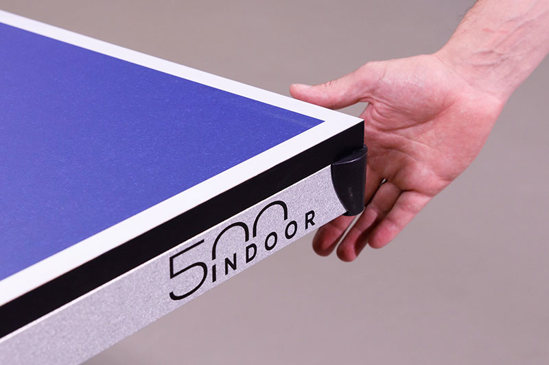 main qui touche le coin de protection de la table de ping pong Cornilleau 500 indoor
